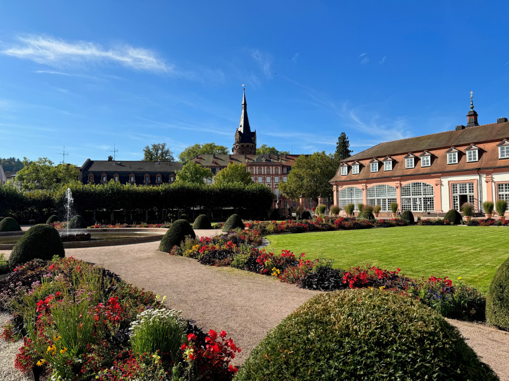 Blick in Park mit Blumen und historischem Gebäude im Hintergrund