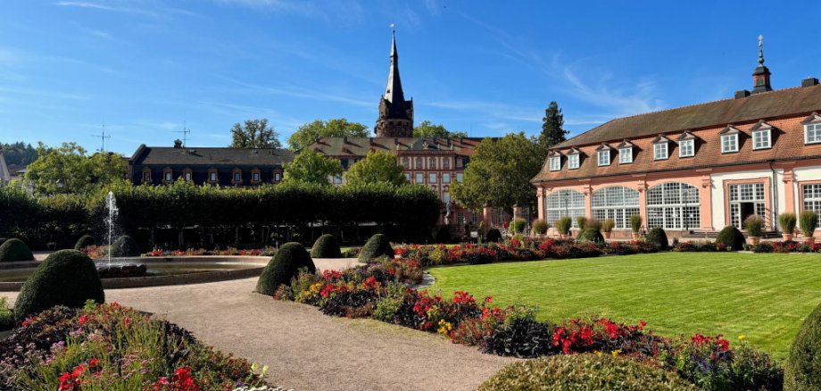 Blick in Park mit Blumen und historischem Gebäude im Hintergrund