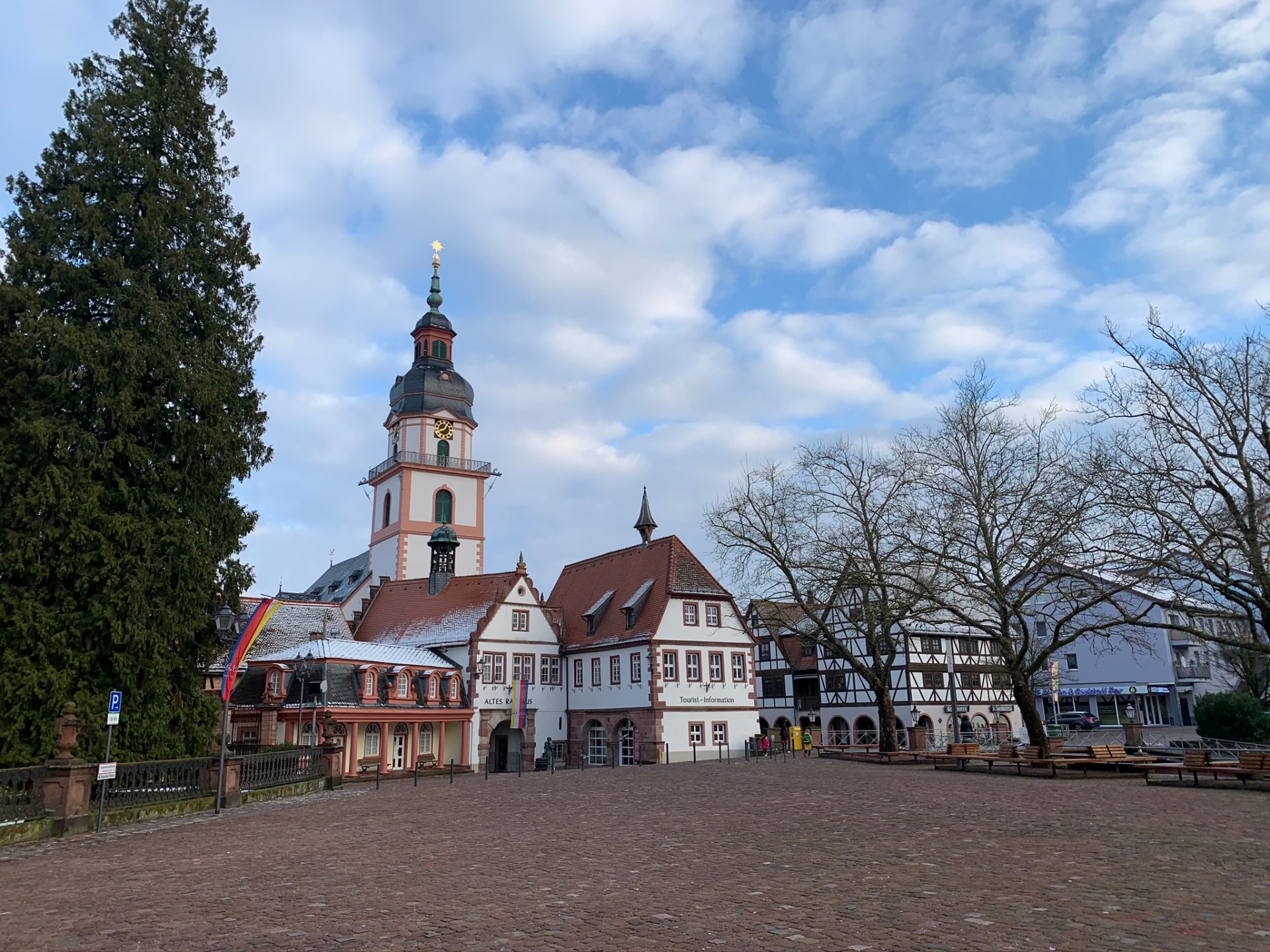 Blick auf einen historischen Marktplatz mit Schloss und Schnee auf den Dächern