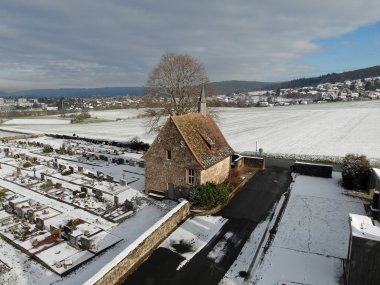 Blick auf Friedhof mit kleiner Kapelle im Schnee