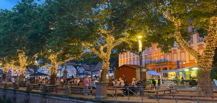 Marktgeschehen auf Marktplatz mit beleuchteten Bäumen