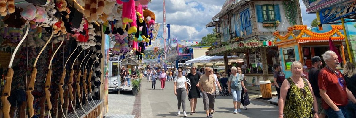 Festplatz Festplatz mit Kuscheltieren an einem Stand links und Menschen in der Mitte