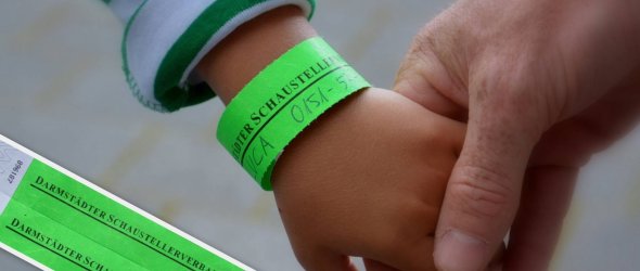 Kinderhandgelenk mit grünem Bändchen, auf dem eine Telefonnummer steht