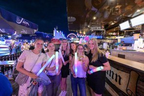Frauen mit Blinklichtern in der Hand, die zu später Stunde auf einem Fest sind.
