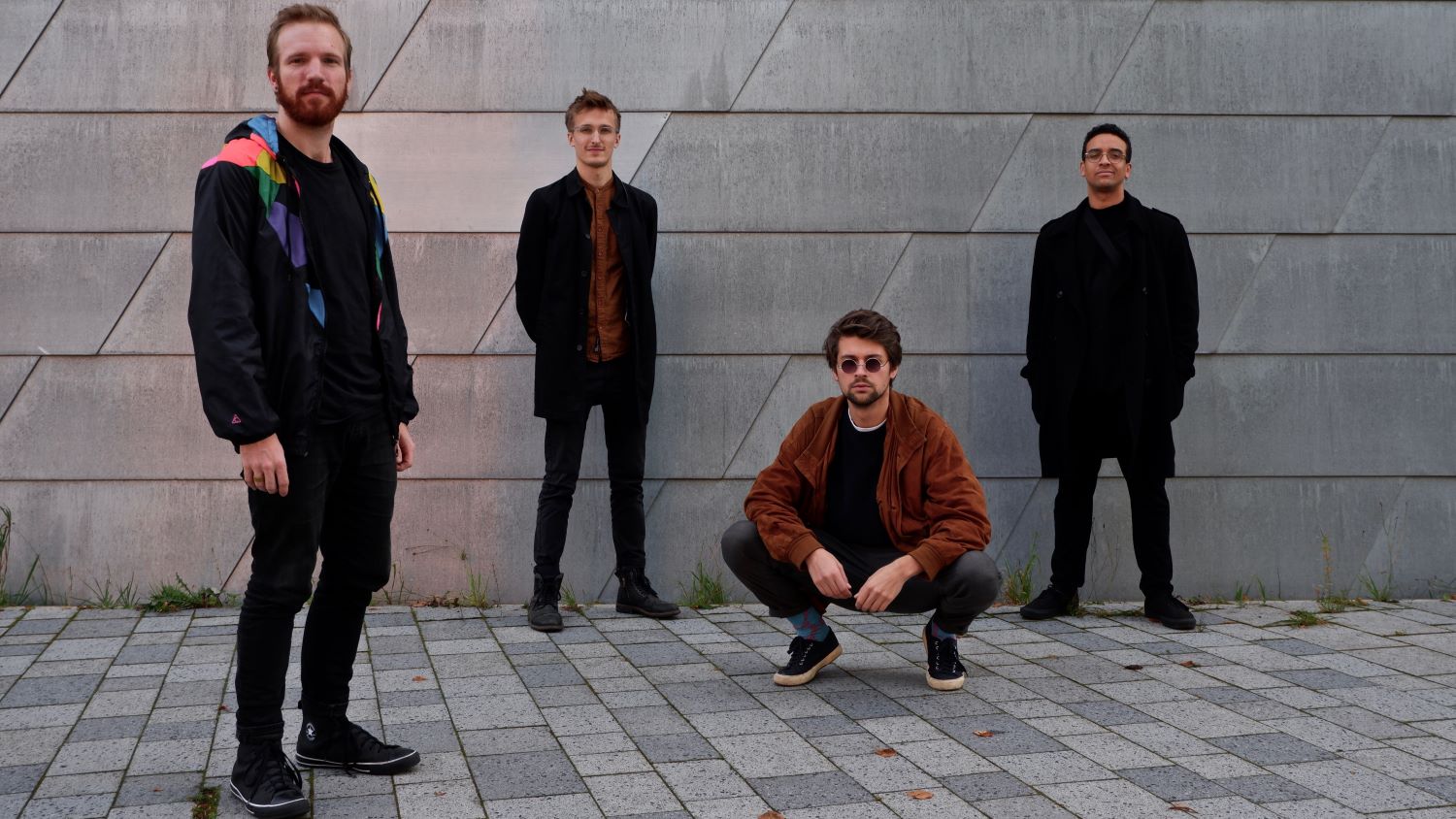 Vier Musiker vor Steinwand