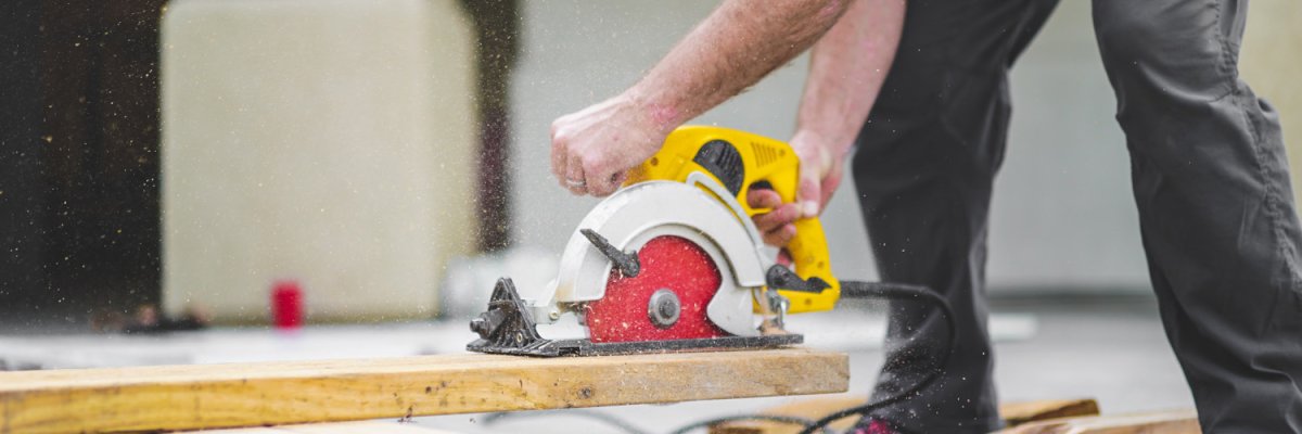 Person schneidet Holz mit Handsäge