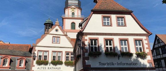 Historisches Gebäude mit Kirchturm im Hintergrund