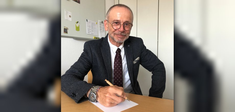 Rentenberater Horst Uebel Mann mit Stift und Block an Schreibtisch