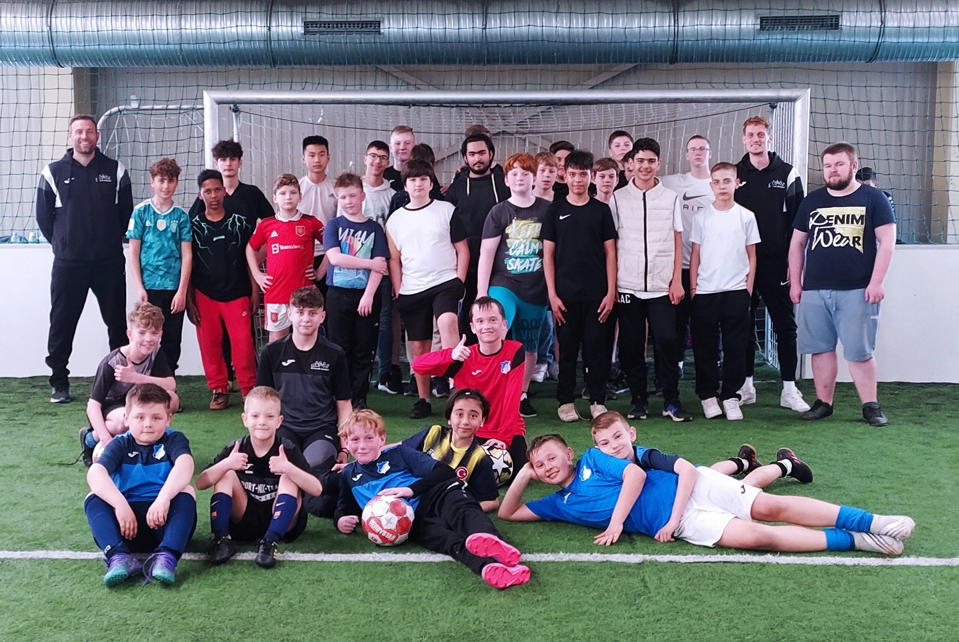 Gruppenbild von Jugendlichen auf Fußballplatz vor Fußballtor