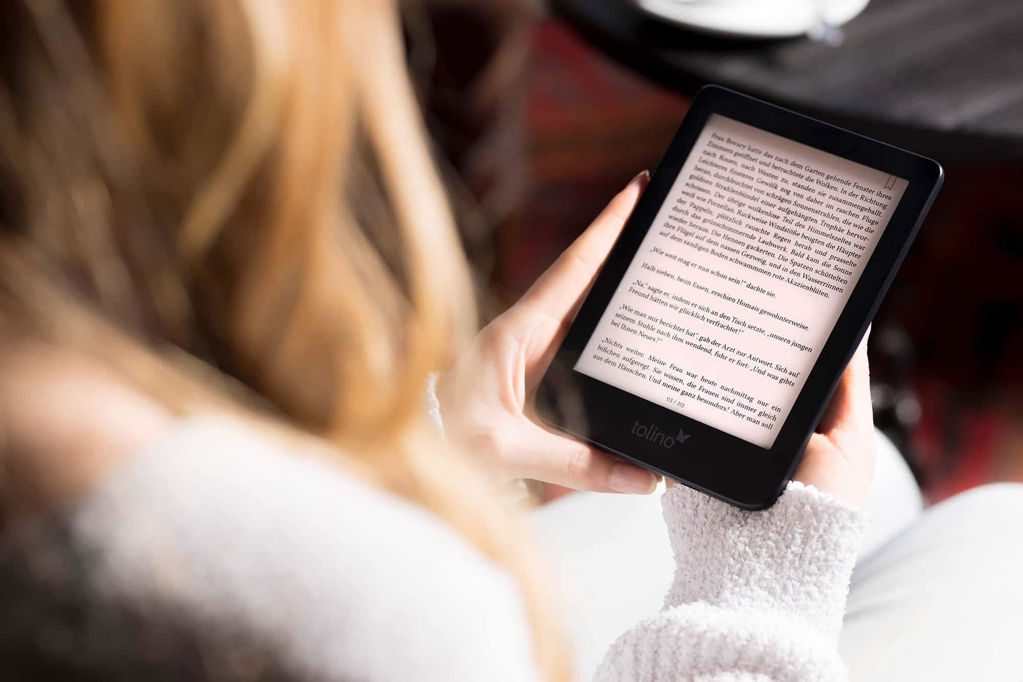 Frau hält E-Reader in Händen und liest