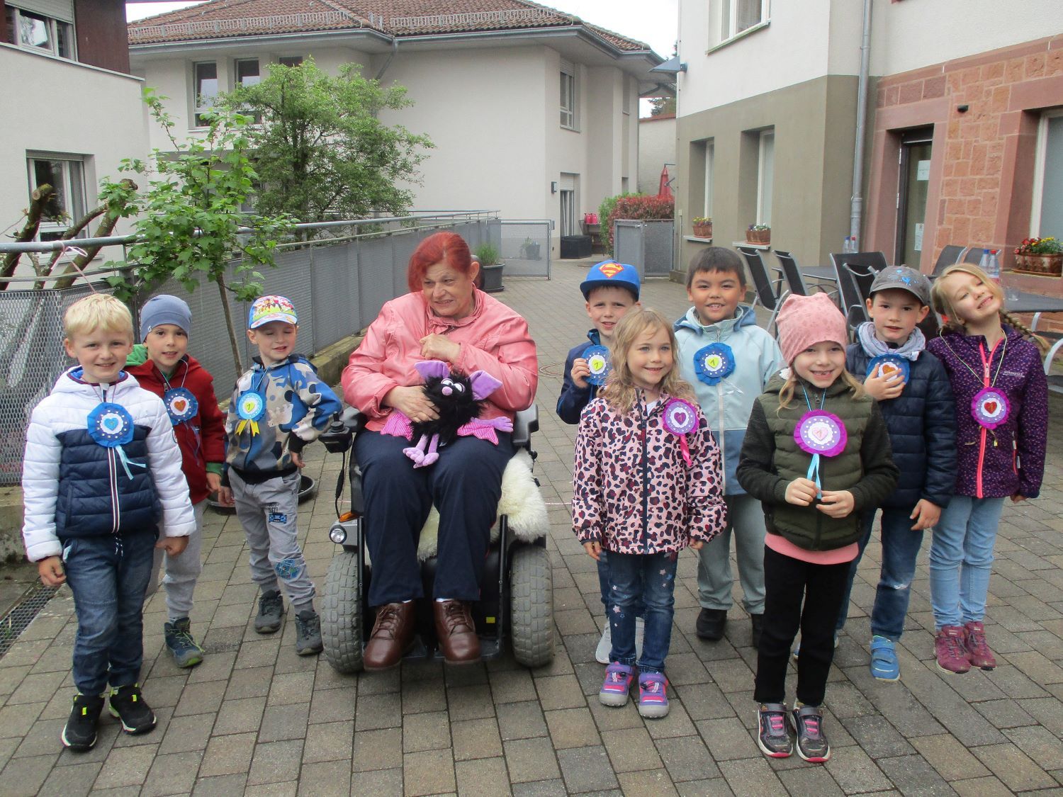 Gruppenbild von Kita-Kindern mit Frau im Rollstuhl