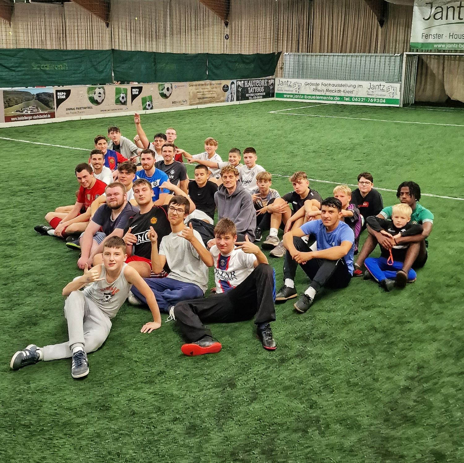Jugendliche sitzen auf Boden in Soccerhalle