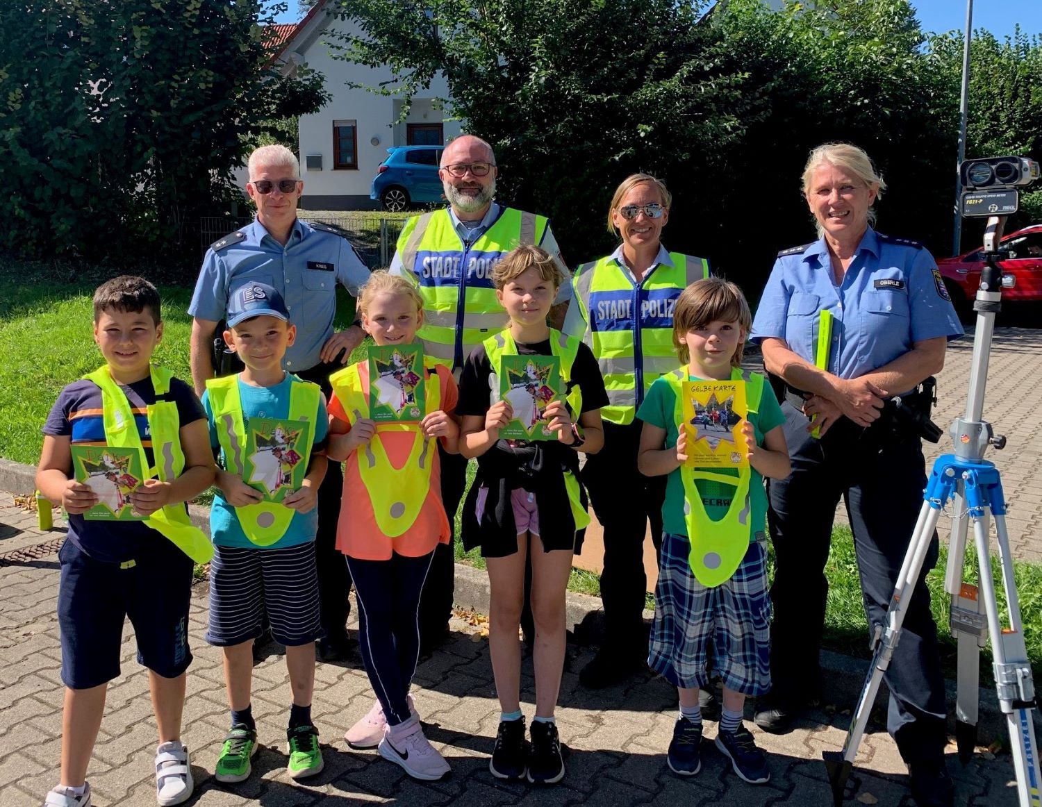 Kinder und Stadtpolizisten sowie Schutzleute vor Ort mit Warnwesten