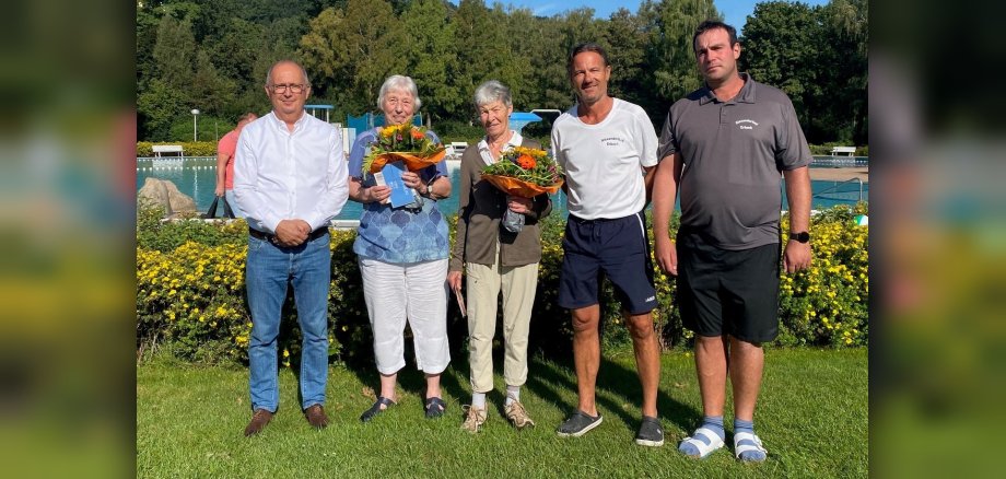 Gruppenbild von drei Männern und zwei Frauen mit Blumensträußen