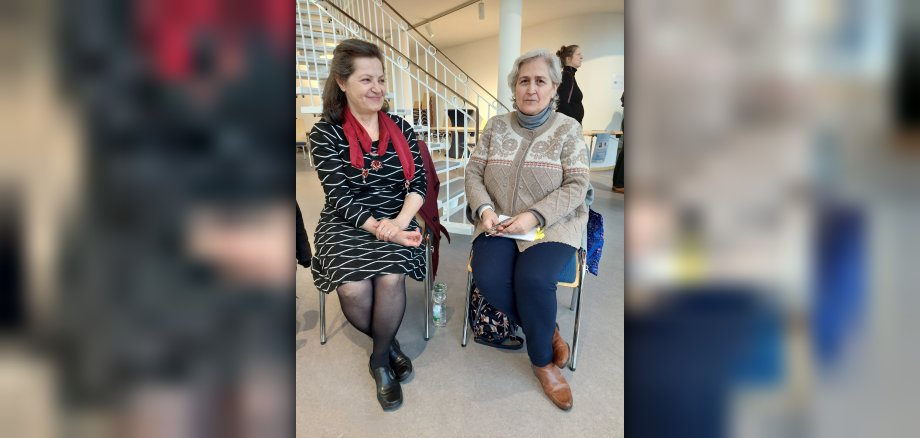 Zwei Frauen sitzen nebeneinander 