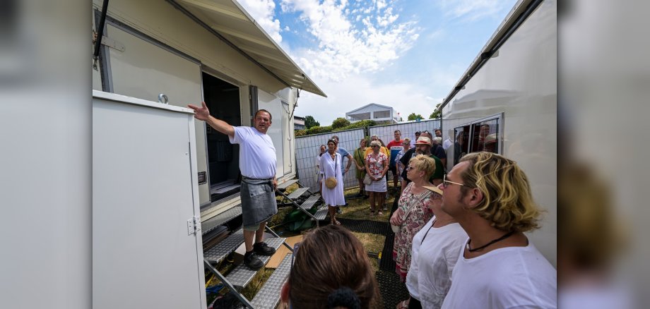 Schausteller zeigt Teilnehmenden den Wiesenmarkt hinter den Kulissen.