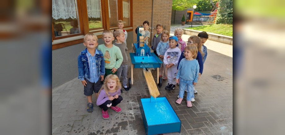 Kindergartenkinder stehen neben neuen Wellenspieler