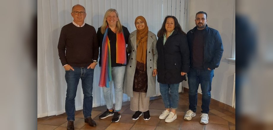 Der Ausländerbeirat, bestehend aus fünf Personen (2 Männer und 3 Frauen) stehen nebeneinander und lächeln in die Kamera.