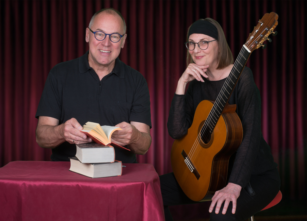Eine Frau mit Gitarre und ein Mann mit Buch