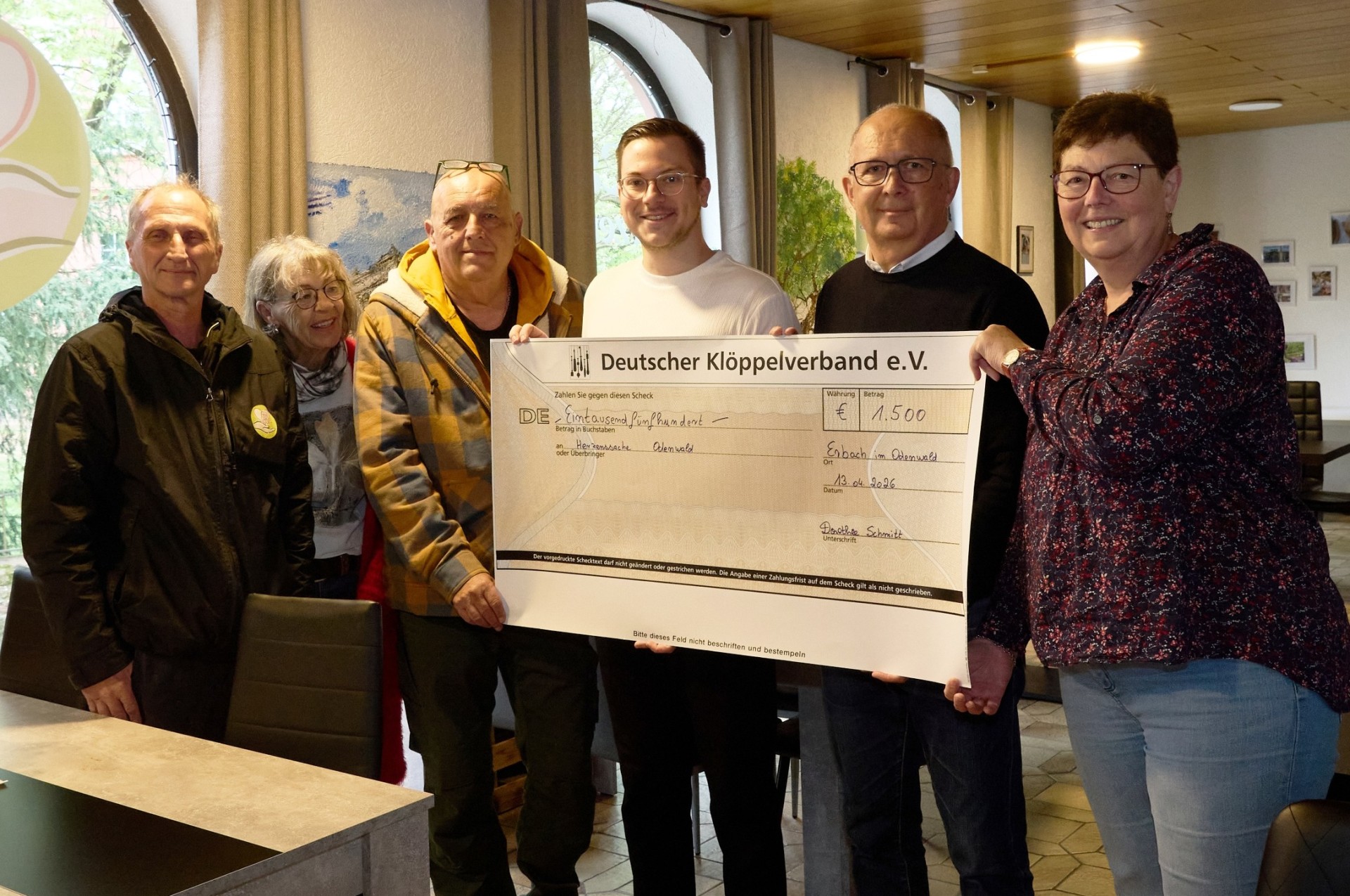 Vier Männer und drei Frauen halten einen großen Spendenscheck bei einer Übergabe fest