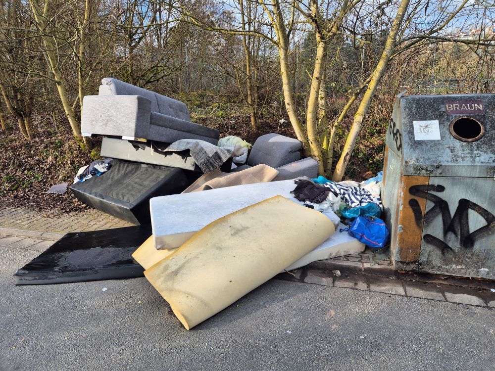 Müll und Sperrmüll, der illegal neben Müllcontainern abgeladen wurde