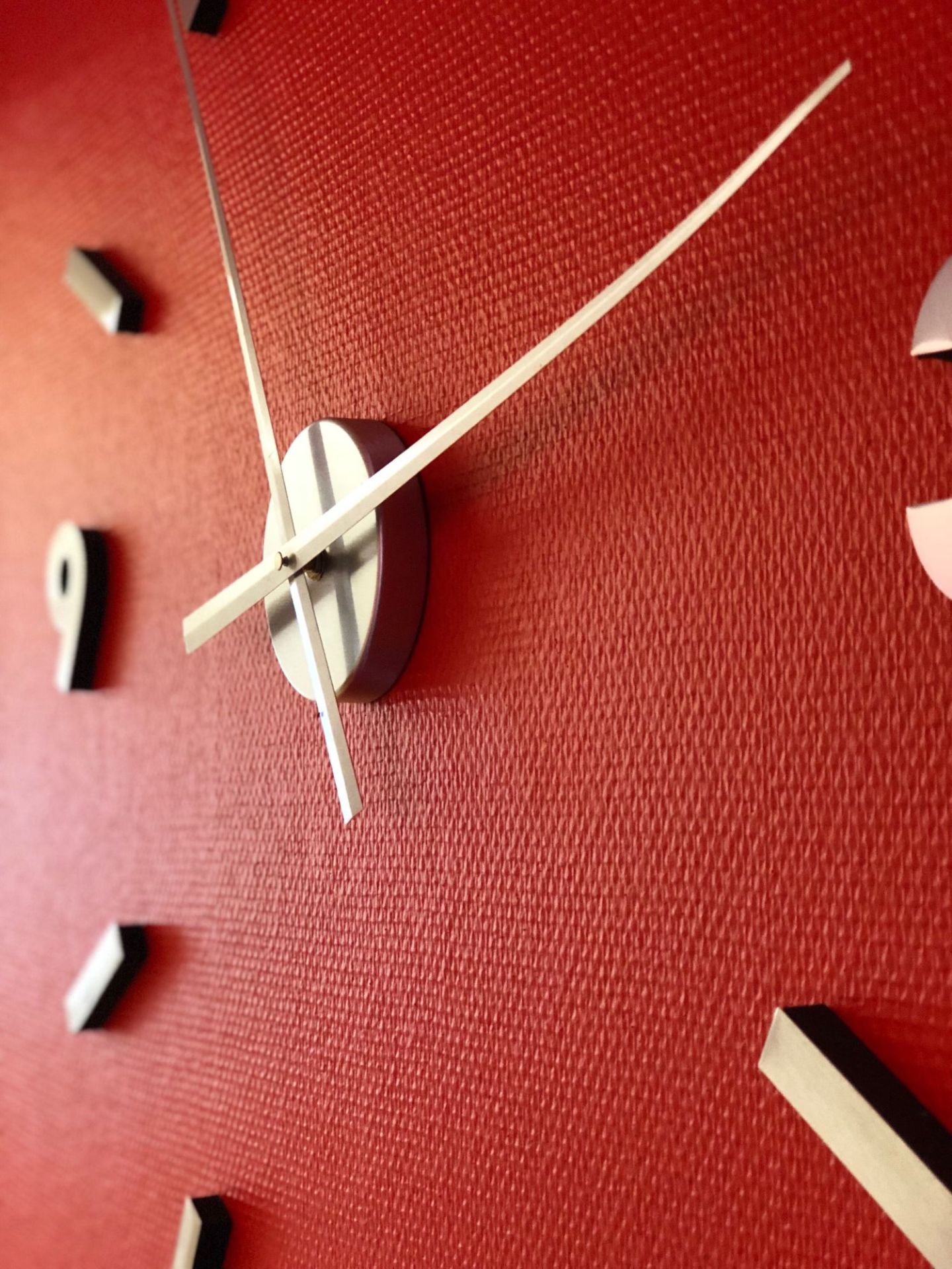 Rote Uhr mit Zeigern in Detailaufnahme