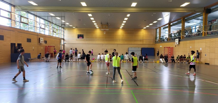 Fair-Play-Fußballturnier in der Schule am Sportpark Kinder spielen in einer Turnhalle Fußball