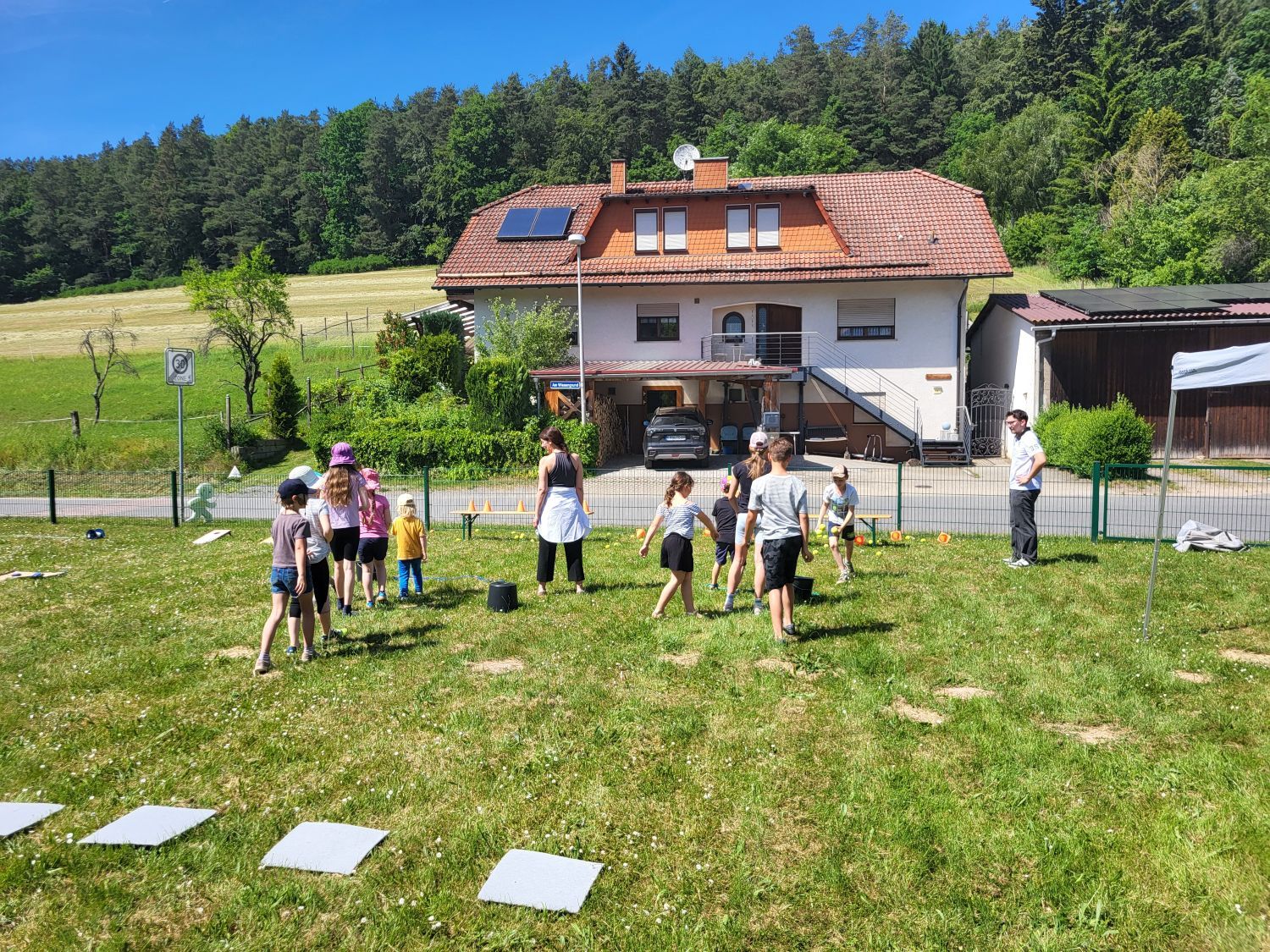 Kinder beim Spielen im Rahmen eines Kinderspielfests auf einer Wiese im Sommer