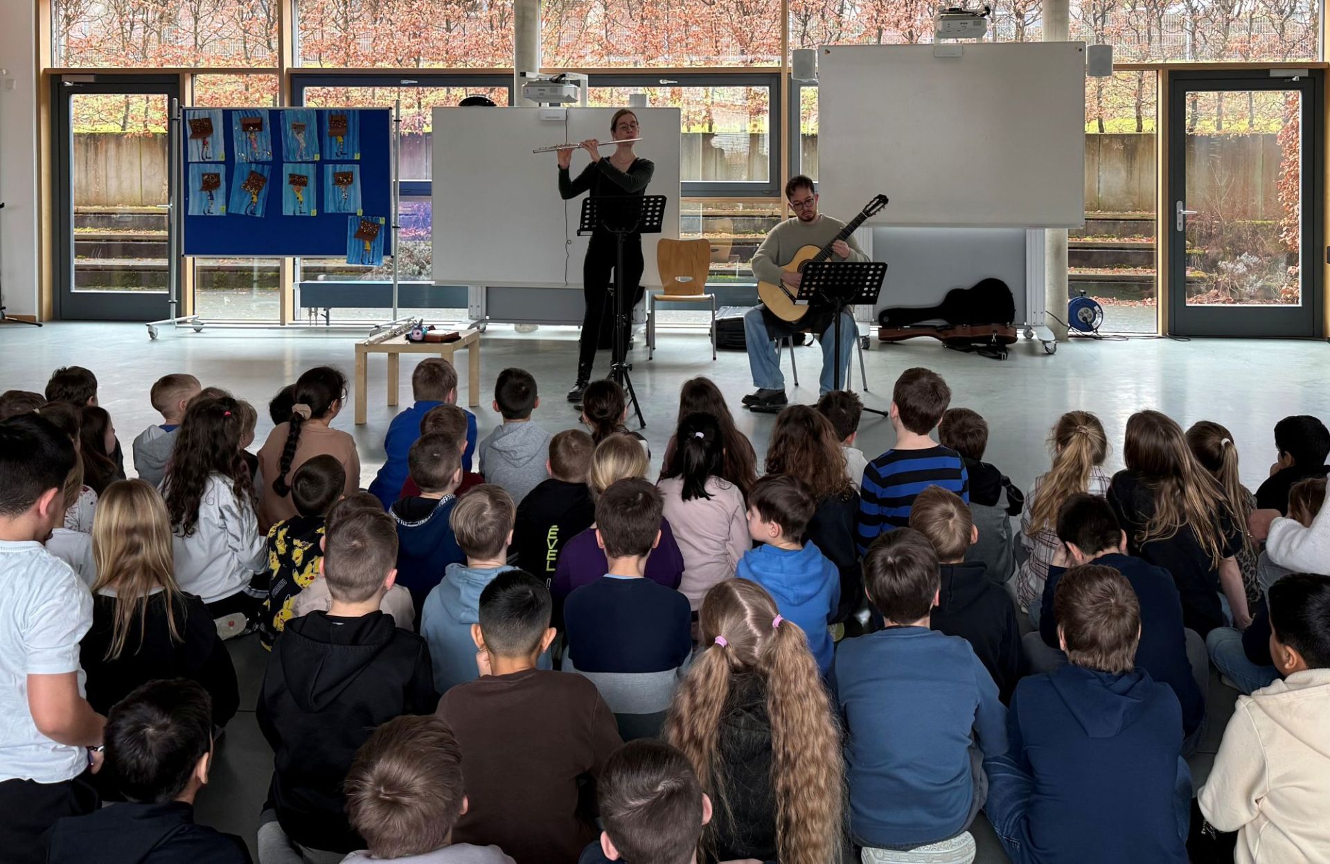 Zwei Musiker geben Konzert vor Schülern