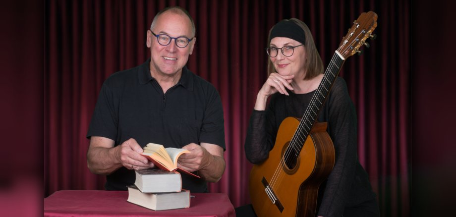 Eine Frau mit Gitarre und ein Mann mit Buch