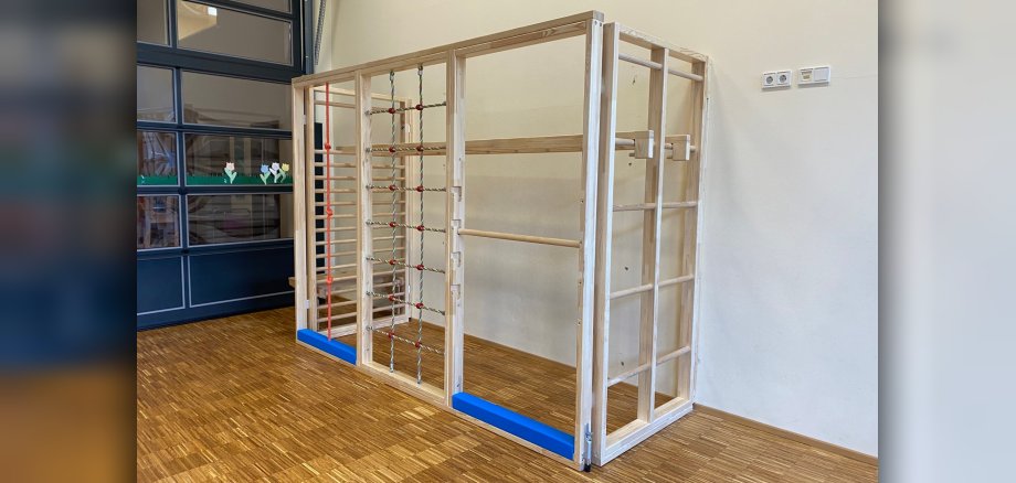 Ein Klettergerüst steht in einer Turnhalle einer Kita.