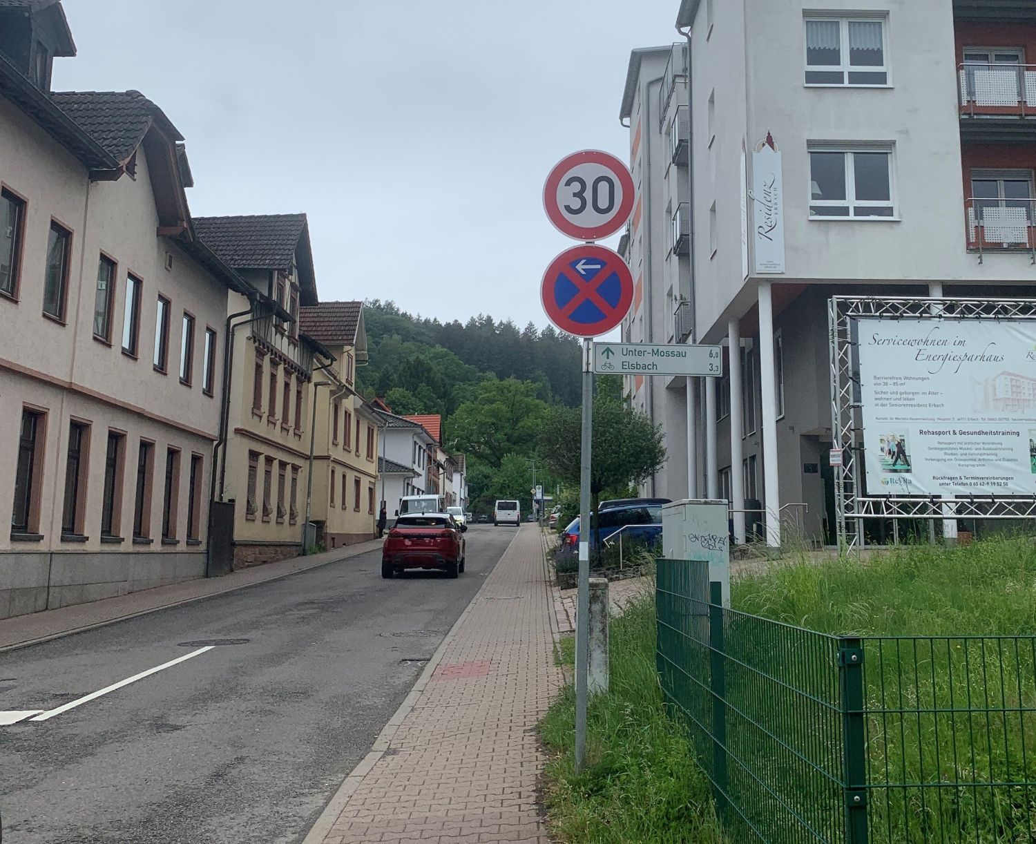 Ein Verkehrszeichen mit Tempo 30 steht am Straßenrand. Auf der Straße daneben fahren Autos.