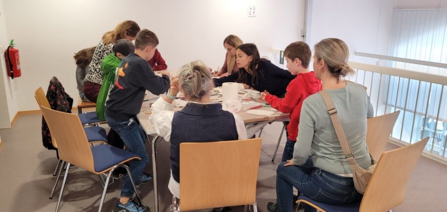 Bastelstunde während des Abschlussfests der Aktion Leseratte Kinder sitzen an einem Tisch und basteln.