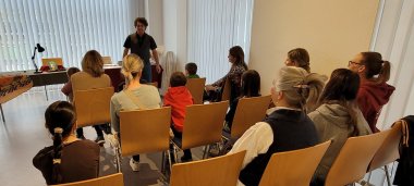 Lesung während des Abschlussfests der Aktion Leseratte Blick auf Publikum, das einem Redner lauscht