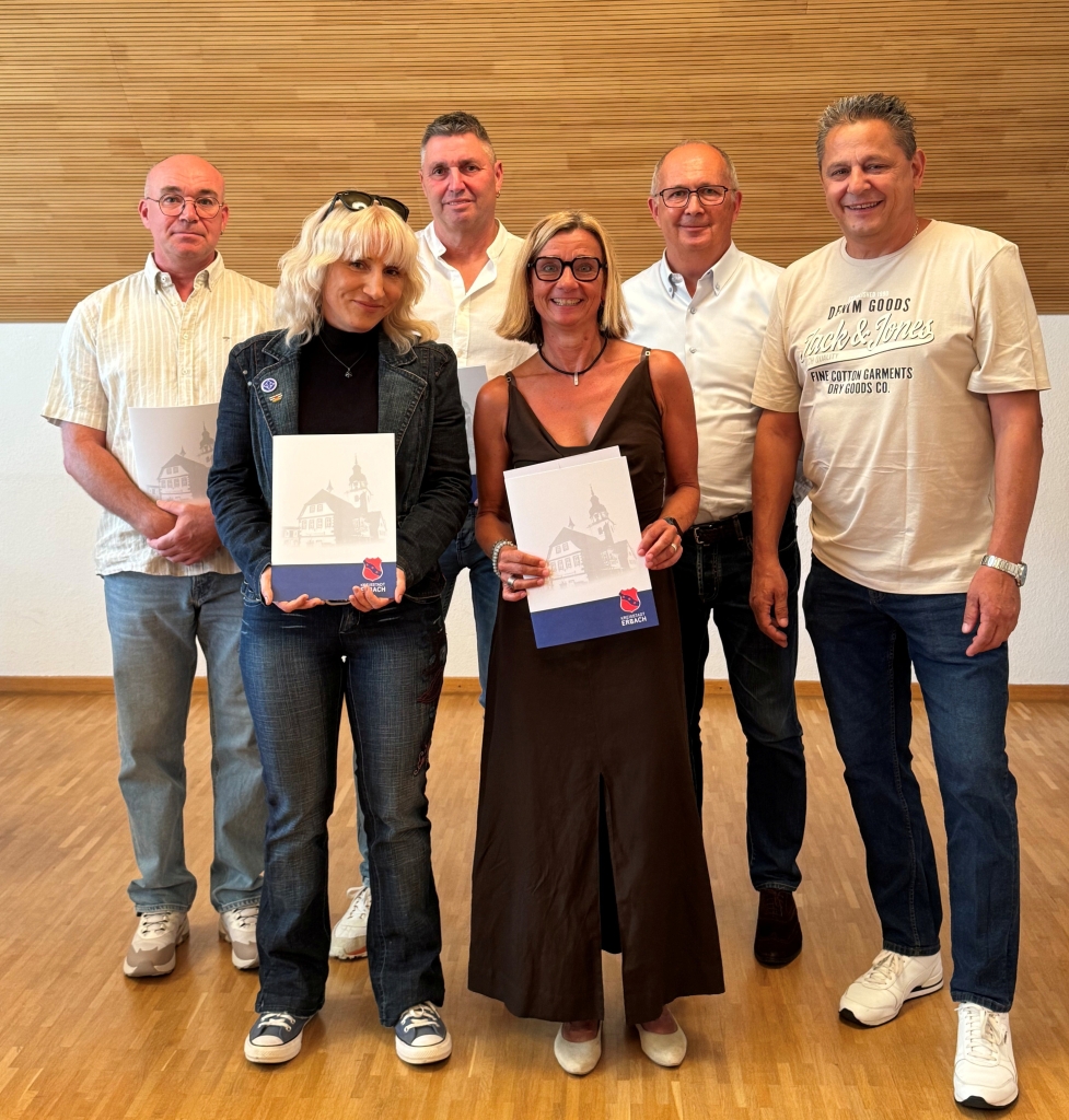 Gruppenbild mit 4 Männern und zwei Frauen. Alle lächeln in die Kameras und die zwei Frauen haben Urkunden in den Händen.