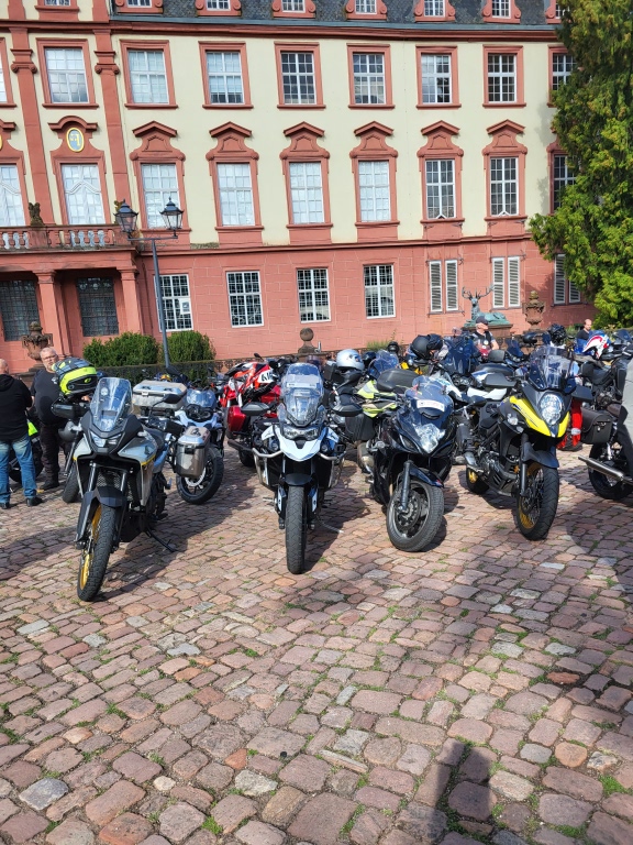 Parkende Motorräder vor einem historischen Schloss.