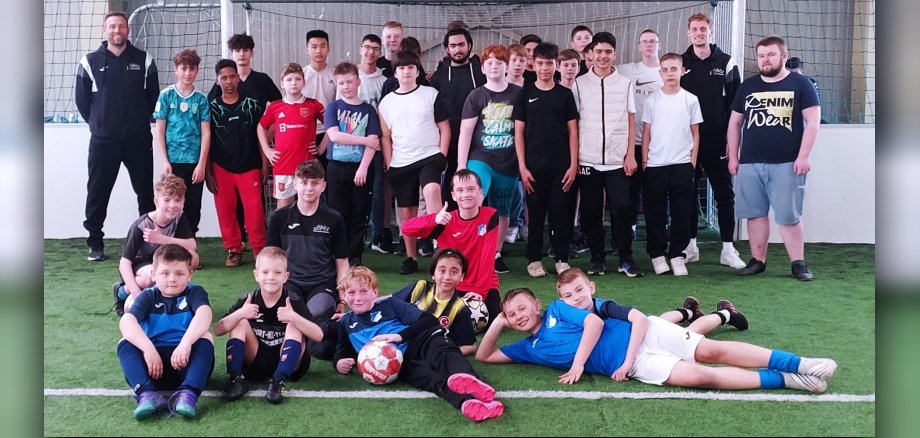 Gruppenbild von Jugendlichen auf Fußballplatz vor Fußballtor