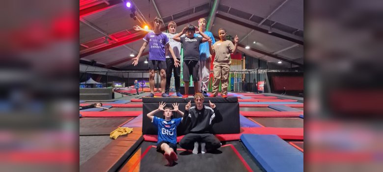 Ausflug in die Trampolinhalle einer Jungstruppe Jugendliche stehen auf Podest in Trampolinhalle
