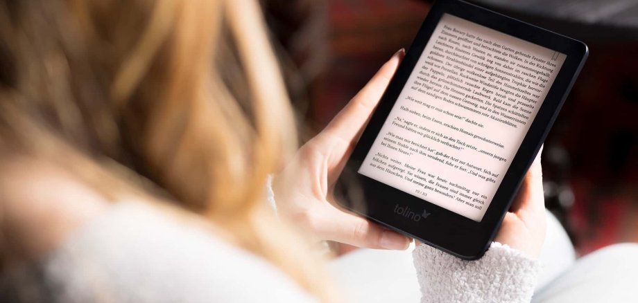 Frau hält E-Reader in Händen und liest