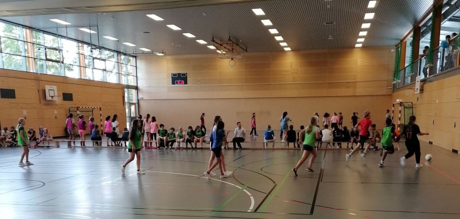 Kinder spielen in Turnhalle Fußball