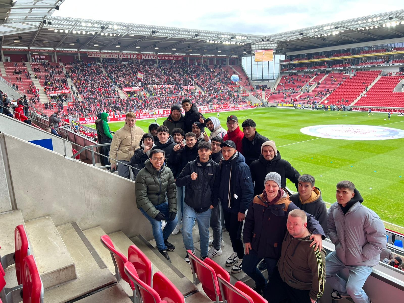 Jugendliche im Fußballstadtion lächeln in die Kamera