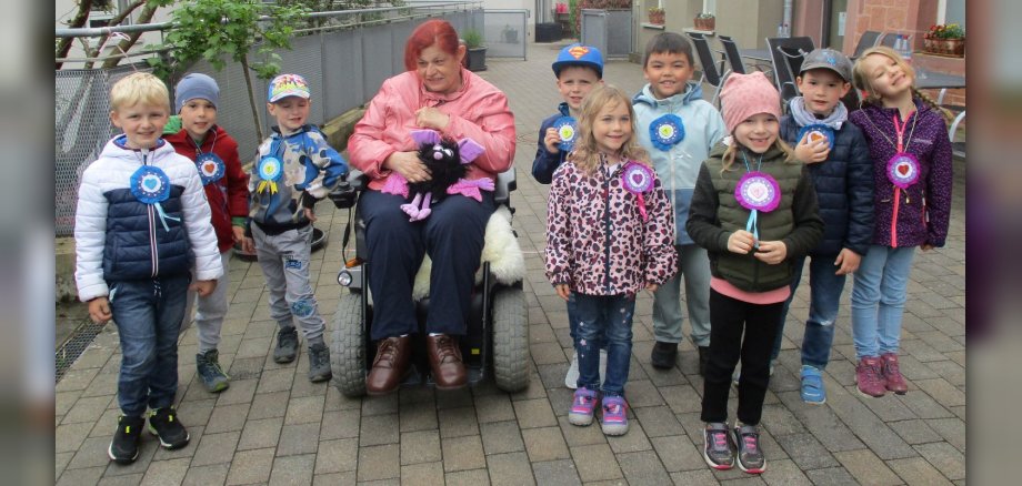 Gruppenbild von Kita-Kindern mit Frau im Rollstuhl