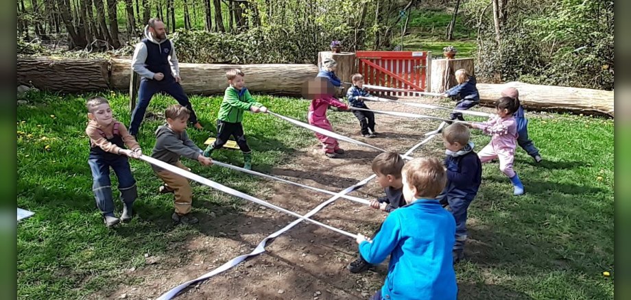 Kinder spielen Tauziehen in der Natur