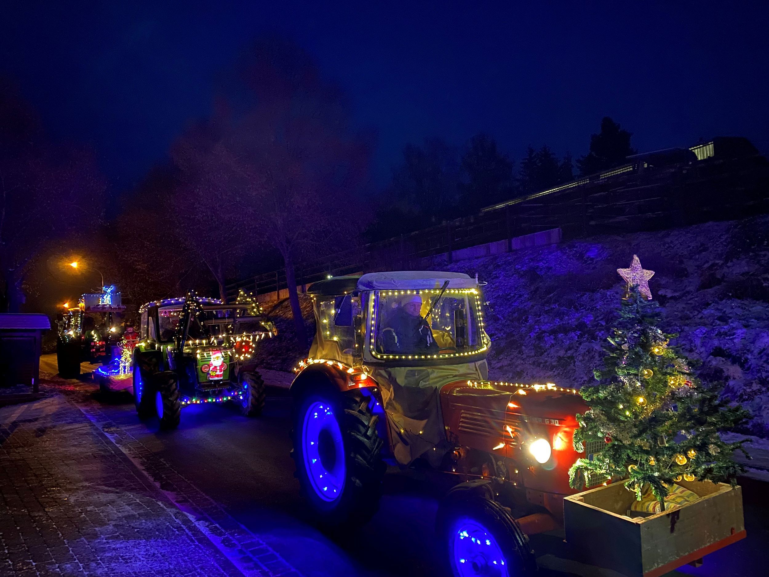 Bunt beleuchtete Traktoren im Dunkeln