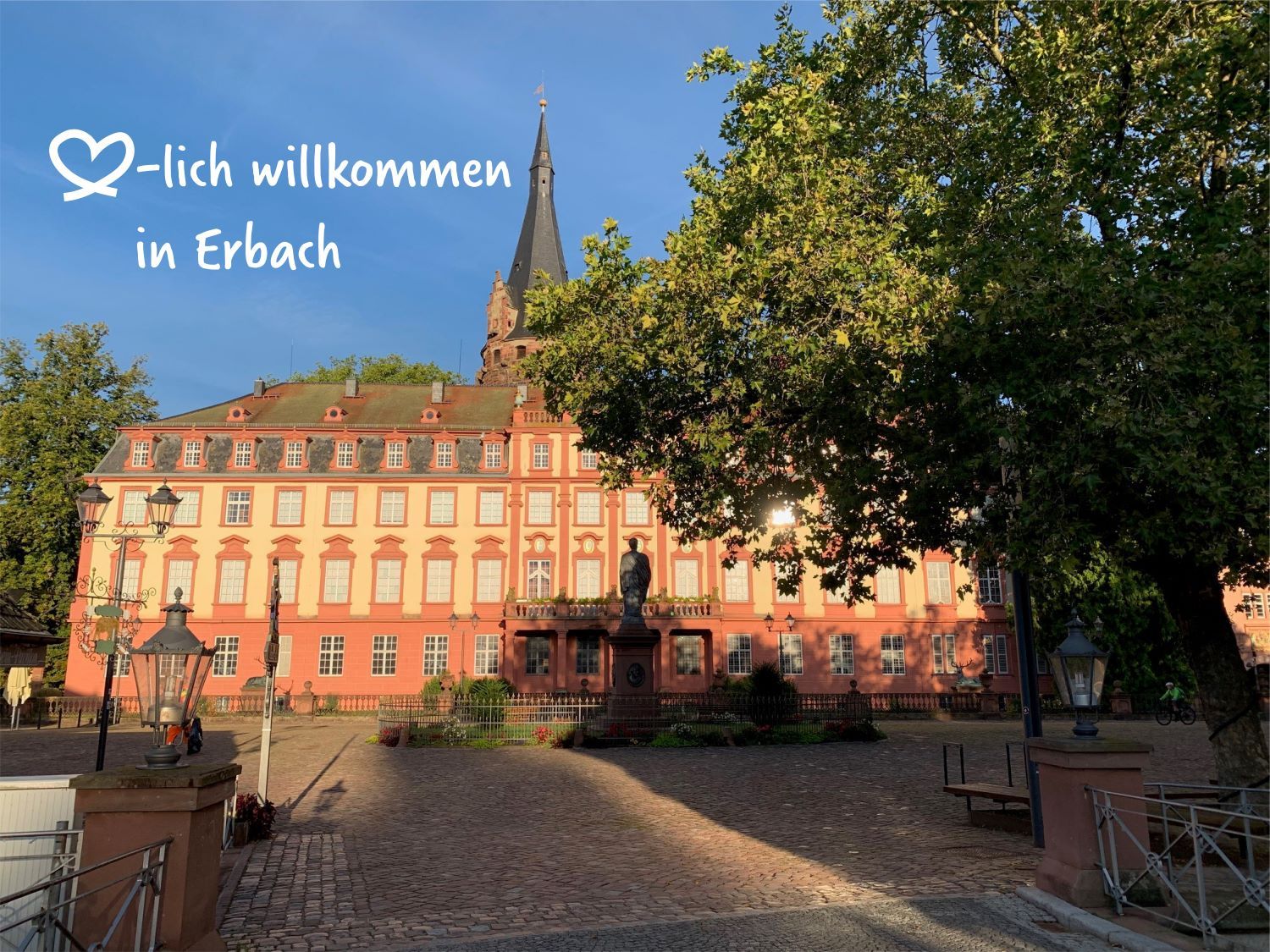 Bild von Schloss mit Marktplatz und Baum sowie Schrift mit "herzlich willkommen"