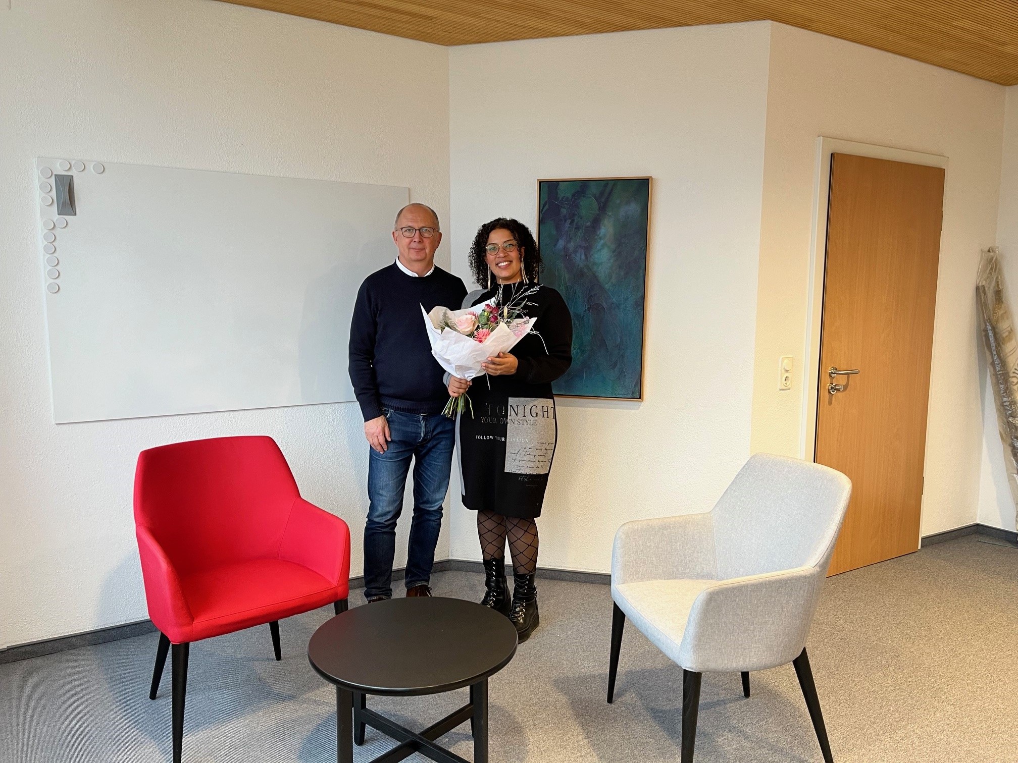 Bürgermeister übergibt Blumenstrauß an Absolventin