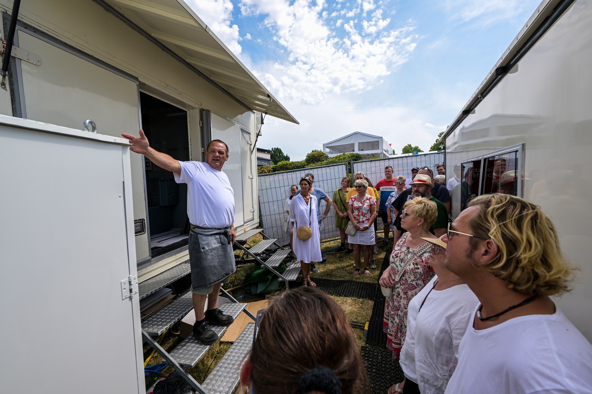 Schausteller zeigt Teilnehmenden den Wiesenmarkt hinter den Kulissen.