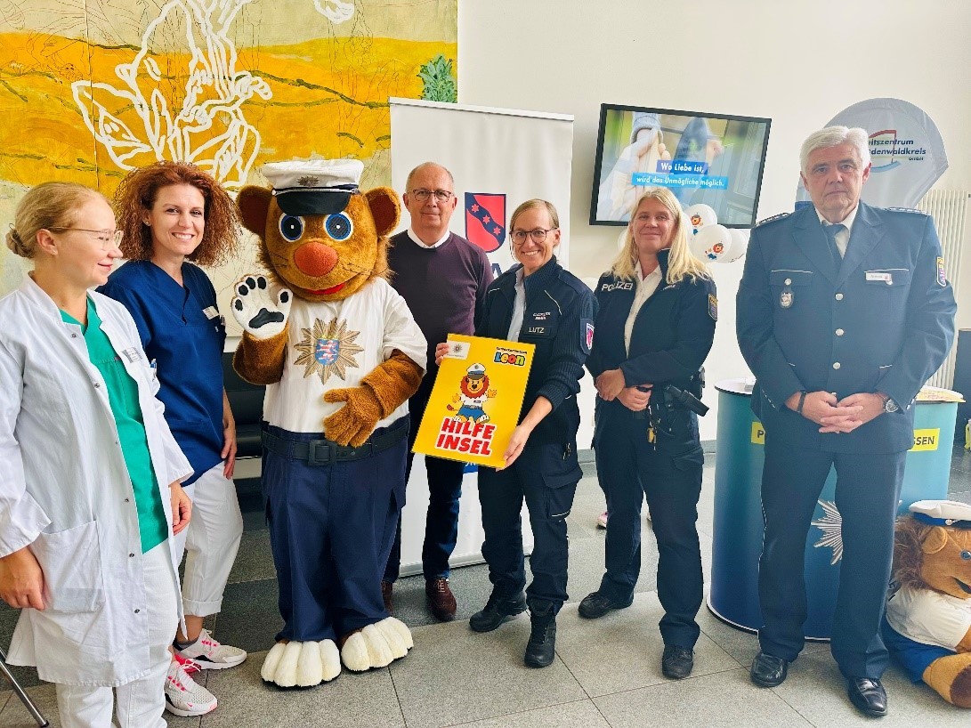 (V. li.): Zusammen mit Kinderkommissar LEON eröffnen Dr. med. Julia Mann (Chefärztin Frauenklinik GZO), Sandra Rapp (Stationsleitung Entbindungsstation GZO), Dr. Peter Traub (Bürgermeister Stadt Erbach), Ariane Lutz (Stadtpolizei Erbach), Carina Oberle (Polizeistation Erbach) sowie Klaus Arnold (Leiter Polizeistation Erbach) die Hilfe-Insel im GZO