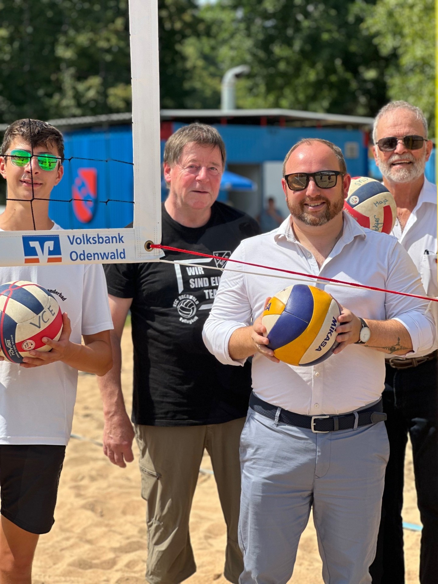 Vertreter der Volksbank Odenwald eG, der Stadt Erbach und des Volleyballvereins halten Volleybälle in der Hand.
