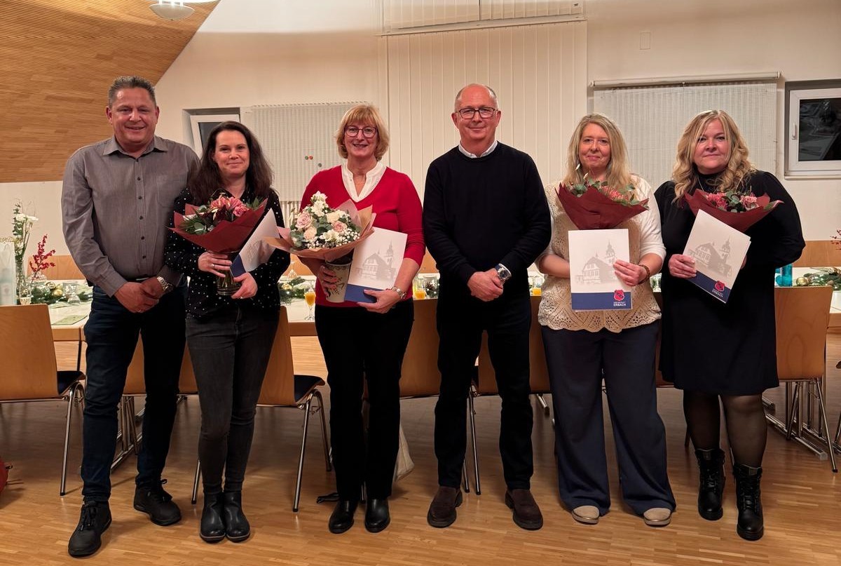 6 Personen, davon 4 mit Blumensträußen und Urkunden